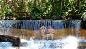 Couple sitting under the waterfall at Tabacon Hot Springs